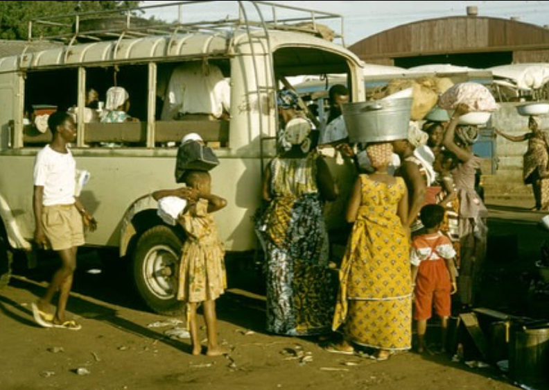 Peki market scene with a bus and women carrying goods, Volta Region historical archive